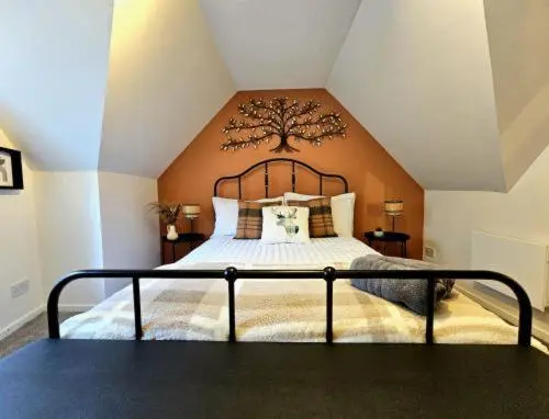 a bedroom with a large bed with a tree headboard at Inverness City Escape! in Inverness