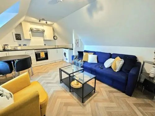 a living room with a blue couch and a table at Inverness City Escape! in Inverness