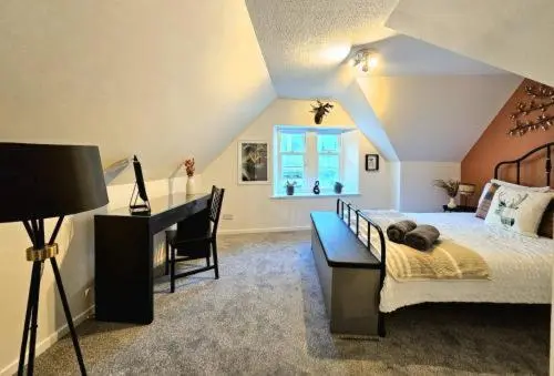 a bedroom with a bed and a desk and a window at Inverness City Escape! in Inverness