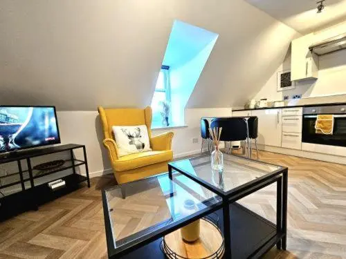a living room with a glass table and a tv at Inverness City Escape! in Inverness