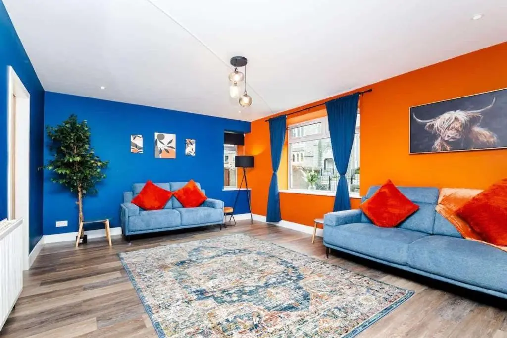 a living room with blue and orange walls at Airport apartment - Aberdeen - Free Parking in Aberdeen