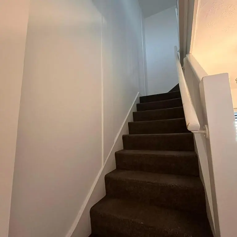 a stairway with brown carpeting and a stair case at Evan Barron Apartment, Inverness in Inverness
