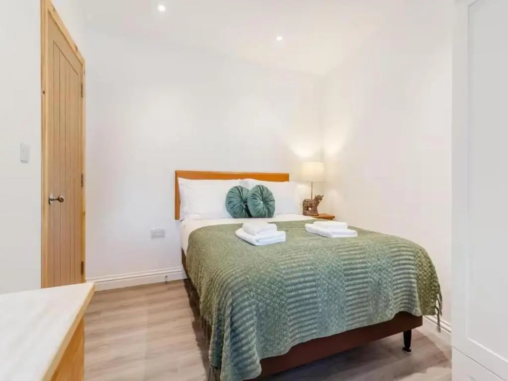 a bedroom with a bed with a green bedspread at Family - Central - Wifi - Parking - Sleeps 4 in Inverness