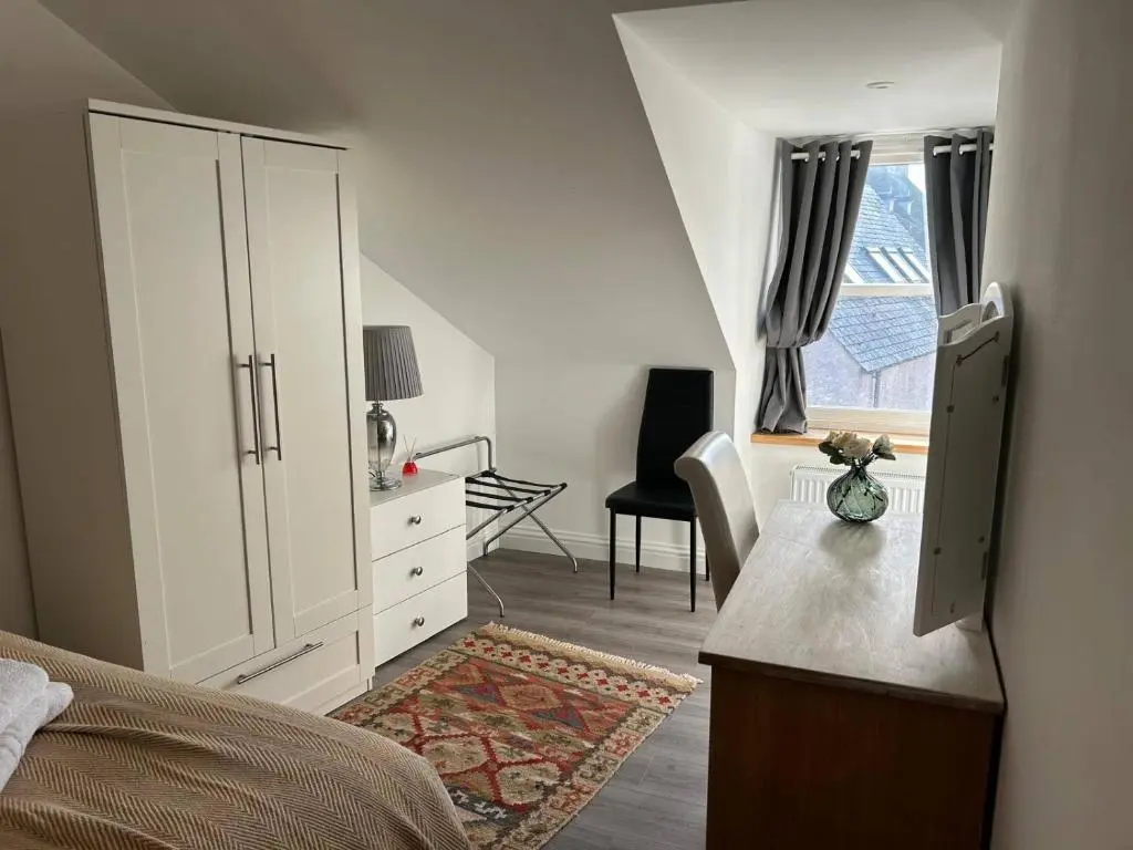 a bedroom with a bed and a dresser and a window at Family - Central - Wifi - Parking - Sleeps 4 in Inverness