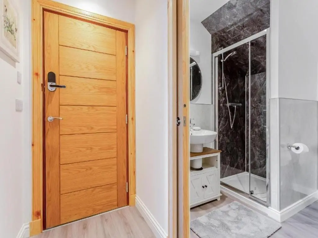 a bathroom with a wooden door and a sink at Family - Central - Parking - Wifi - Sleeps 3 in Inverness