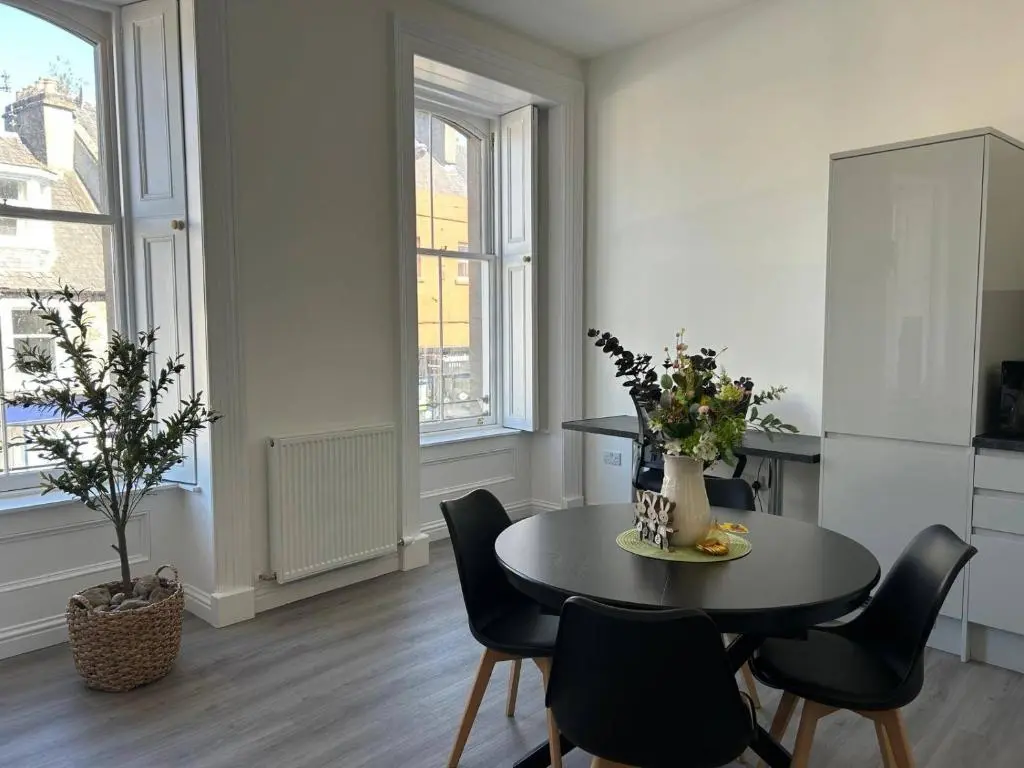 a dining room with a black table and chairs at Family - Parking - Central - Wifi - Sleeps 4 in Inverness