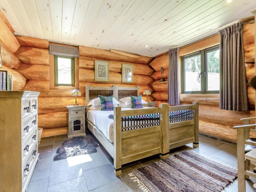 a bedroom with a bed in a log cabin at Strix - Uk50082 in Struy