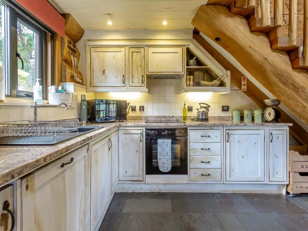 a kitchen with white cabinets and a staircase at Strix - Uk50082 in Struy