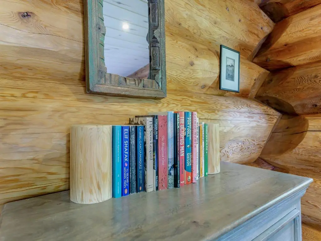 a row of books on a shelf with a mirror at Parus - Uk50083 in Beauly
