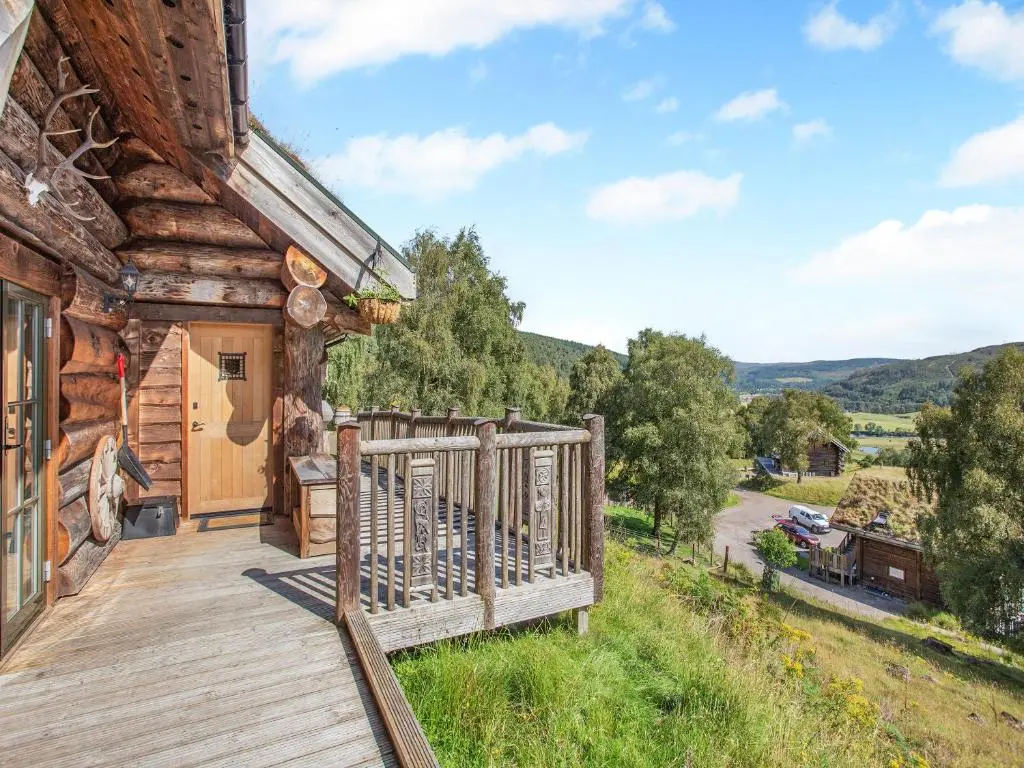 a wooden deck on the side of a log cabin at Parus - Uk50083 in Beauly