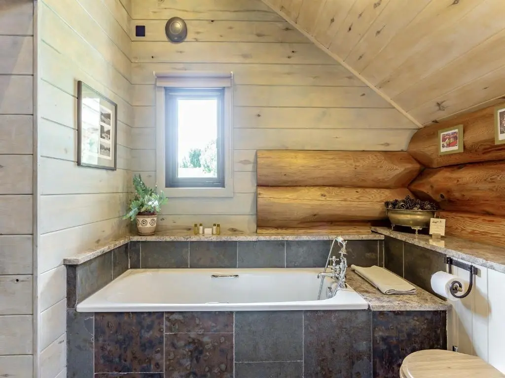 a large tub in a bathroom with wooden walls at Buteo - Uk50068 in Struy