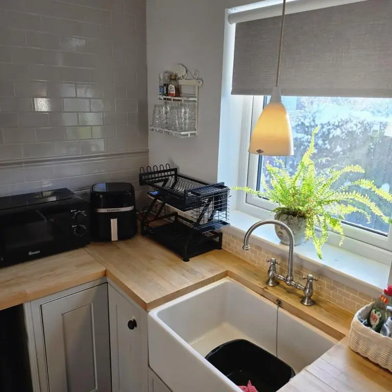 a kitchen with a sink and a window at Shamus cottage in Alness
