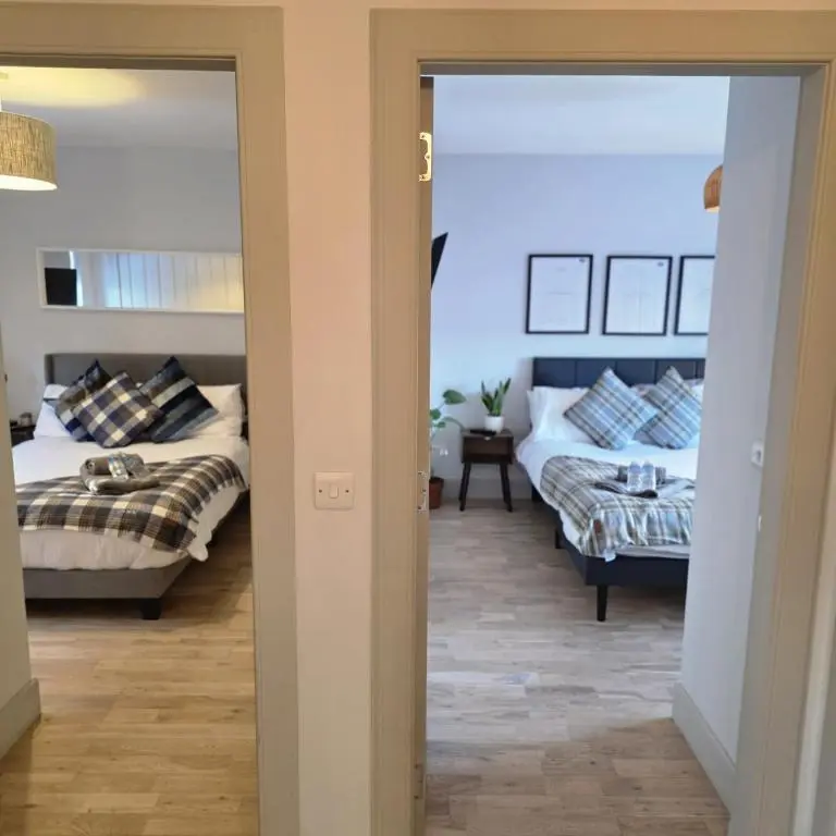 a bedroom with two beds and a couch at Shamus cottage in Alness