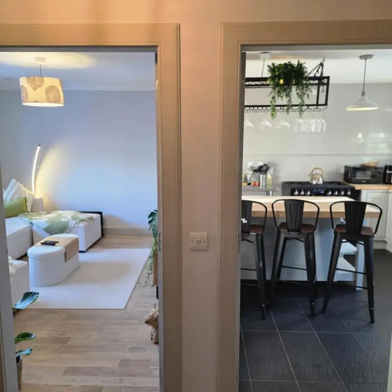 a kitchen and living room with a table and chairs at Shamus cottage in Alness
