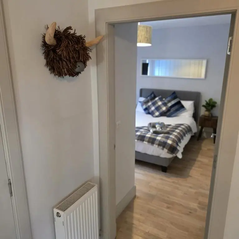 a view of a bedroom with a bed and a mirror at Shamus cottage in Alness