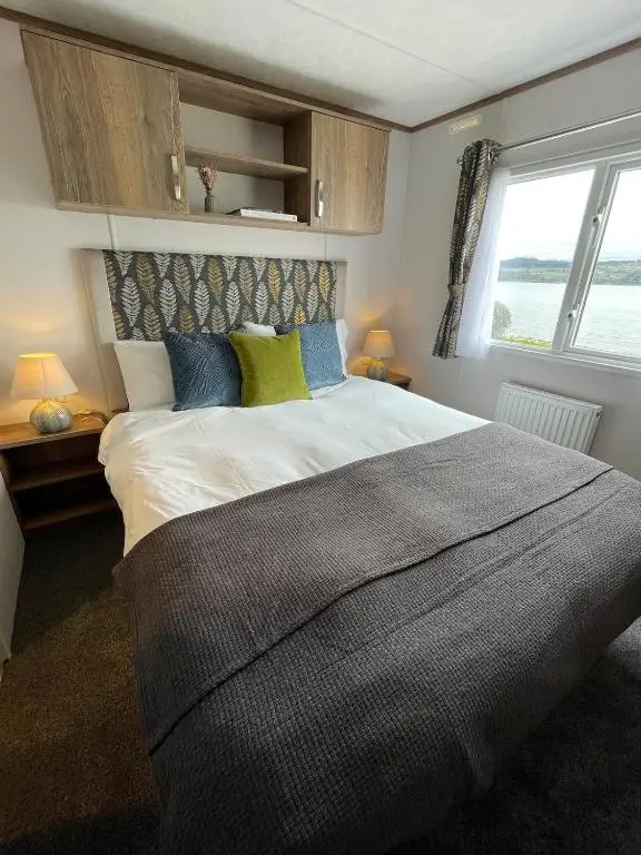 a bedroom with a large bed with a window at Brand New Beautiful Home close to Inverness in North Kessock