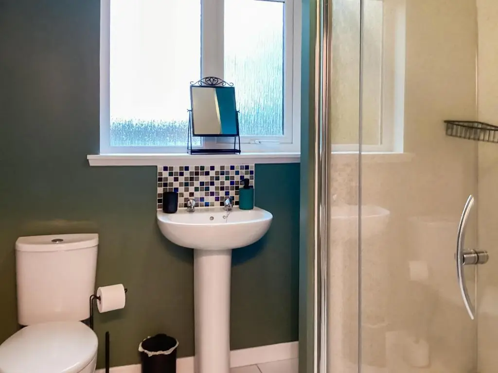 a bathroom with a sink and a toilet and a window at Uppermill Farm in Tarves
