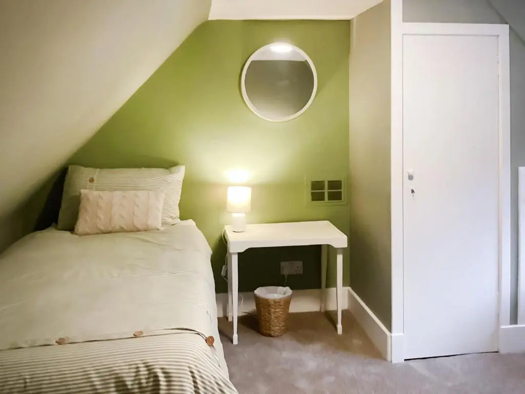 a bedroom with a bed and a table with a mirror at Uppermill Farm in Tarves