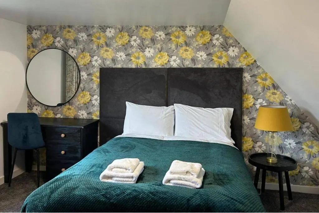 a bedroom with a bed with two towels on it at Hot tub - Garden - Bbq - Parking - Pets - Sleeps 6 in Strathpeffer