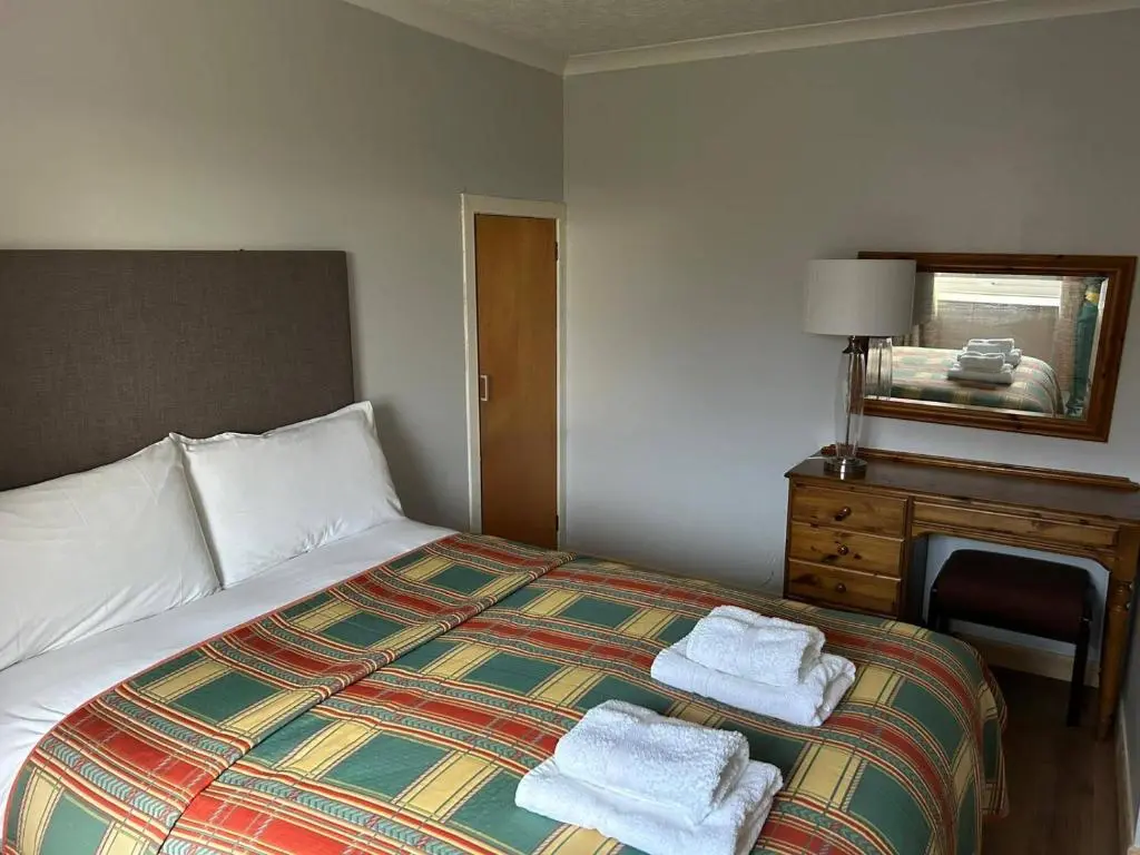 a hotel room with a bed with towels on it at Hot tub - Garden - Bbq - Parking - Pets - Sleeps 6 in Strathpeffer