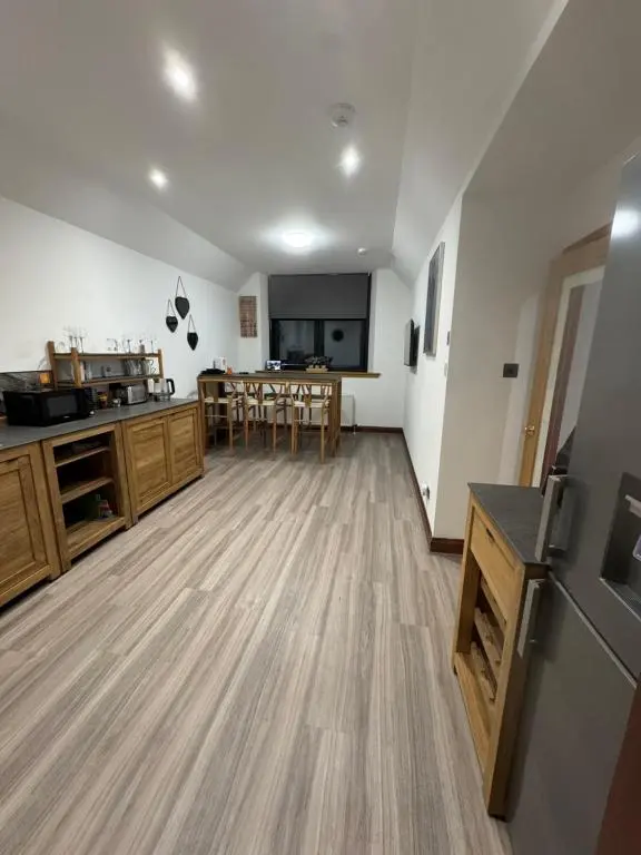 a large kitchen and dining room with wooden floors at TSB Accommodation in Turriff