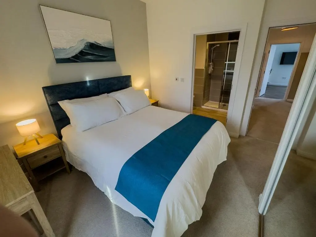 a bedroom with a bed with a blue and white blanket at Beinn View in Inverness