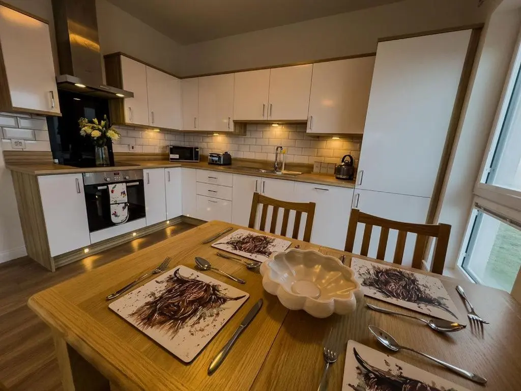 a kitchen with a wooden table with utensils on it at Beinn View in Inverness
