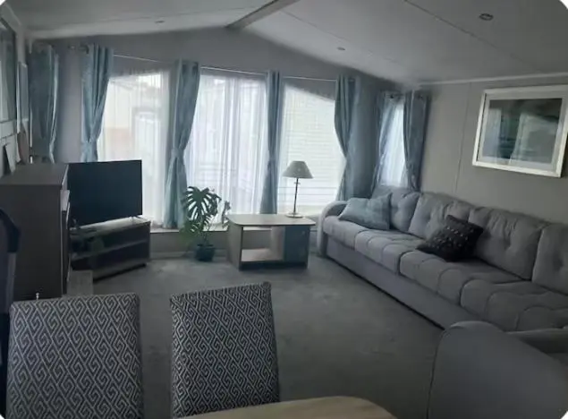 a living room with a couch and a tv at Moray Coast getaway in Lossiemouth