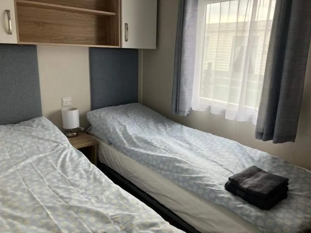 a small bedroom with two beds and a window at Moray Coast getaway in Lossiemouth