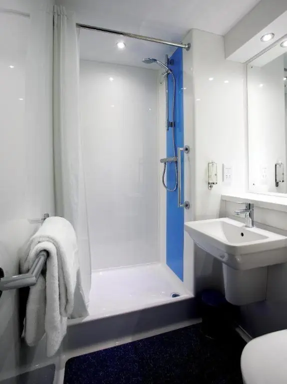 a white bathroom with a shower and a sink at Travelodge Inverness Fairways in Inshes