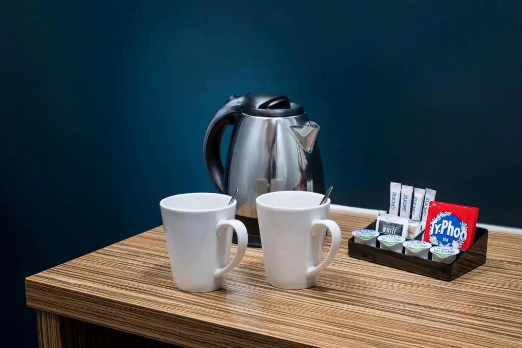 a tea pot and two cups on a table at Travelodge Aberdeen Bucksburn in Aberdeen