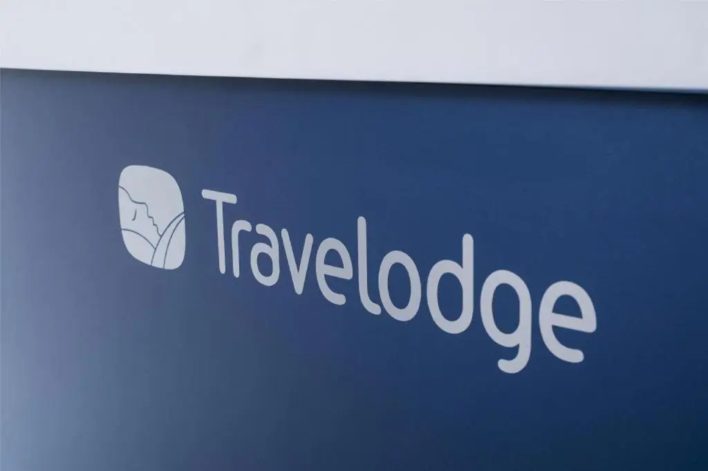 a sign for a travel loadage company on a wall at Travelodge Aberdeen Bucksburn in Aberdeen
