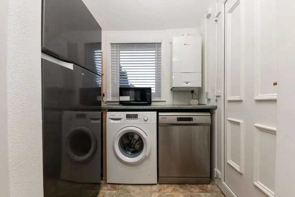 a kitchen with a washing machine and a washer at Century House - 4BR - Free Parking - City Centre in Inverness