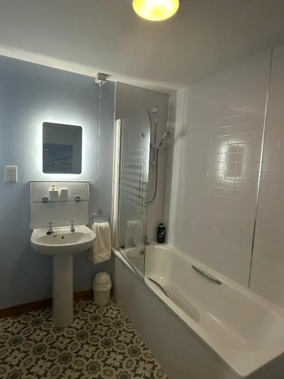 a bathroom with a sink and a shower and a tub at LaScala Apartment in Inverness