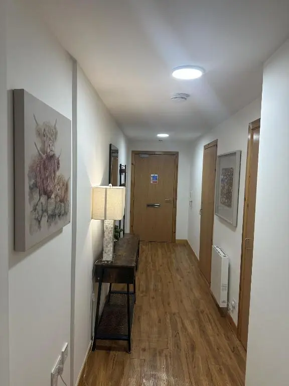 a hallway with a table and a door in a room at LaScala Apartment in Inverness