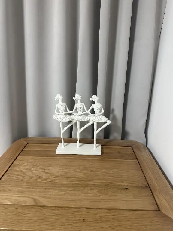 a white figurine of three women on a table at LaScala Apartment in Inverness