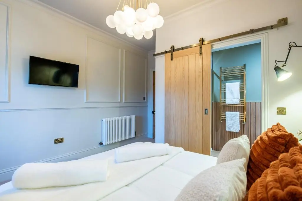 a bedroom with a bed and a tv on the wall at Luxury New Inverness Apartment in a Prime Location in Inverness