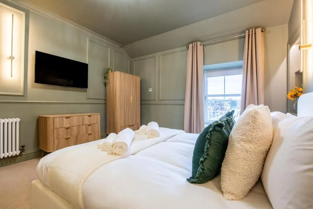 a bedroom with a large white bed with a window at Luxury New Inverness Apartment in a Prime Location in Inverness