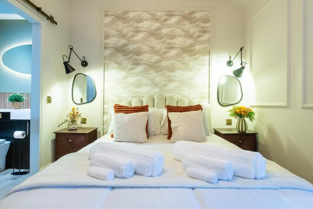 a bedroom with a large white bed with two mirrors at Luxury New Inverness Apartment in a Prime Location in Inverness