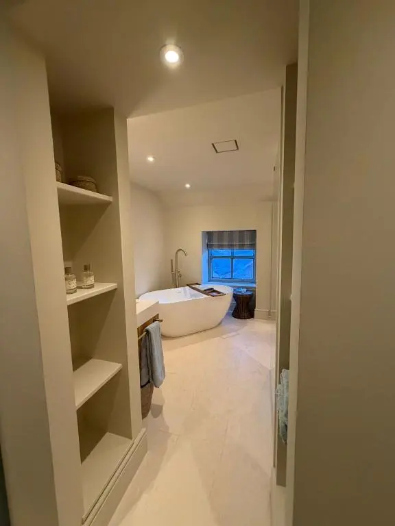 a bathroom with a bath tub and a large room at Gilchrist Square in Dornoch