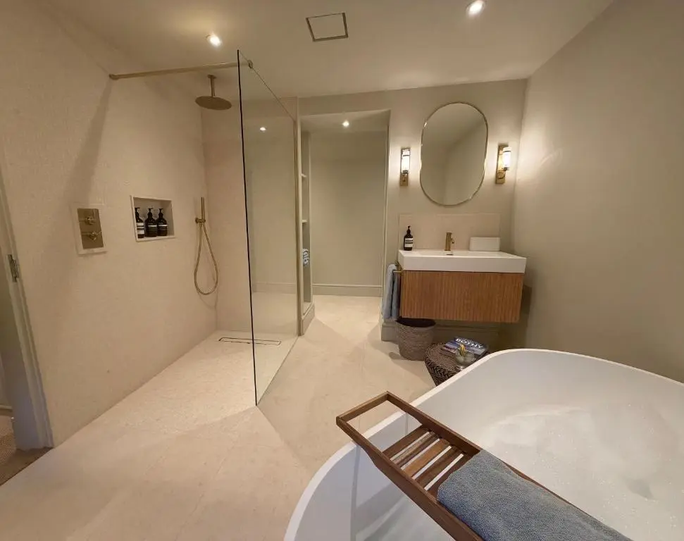 a bathroom with a shower and a tub and a sink at Gilchrist Square in Dornoch