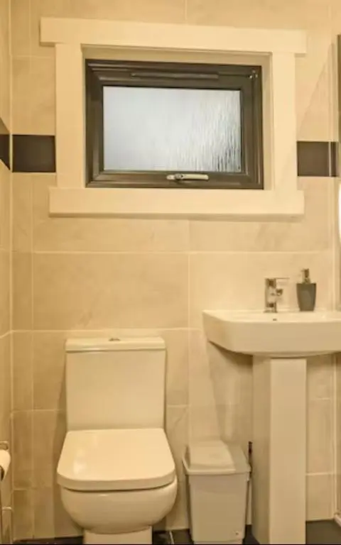 a bathroom with a toilet and a sink and a window at Cateran Rest in Kirkmichael
