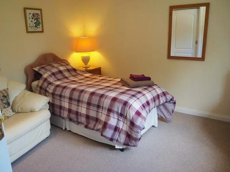 a bedroom with a bed and a lamp and a couch at 3 Bed in Drybridge oc-w34891