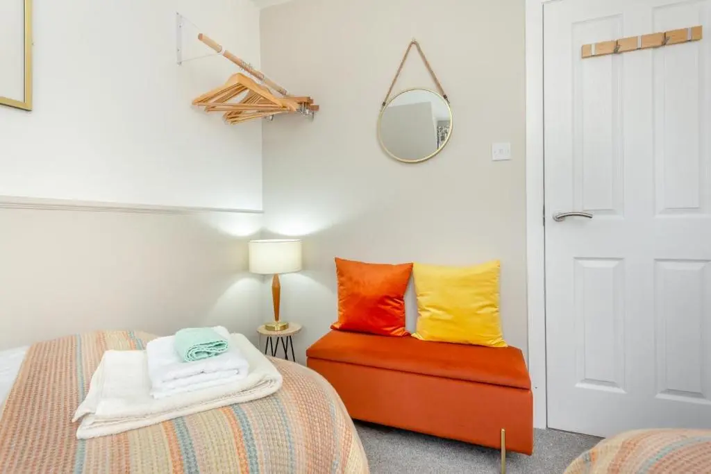 a bedroom with a bed with colorful pillows and a mirror at 2 Bed in Nairn oc-t34496 in Nairn