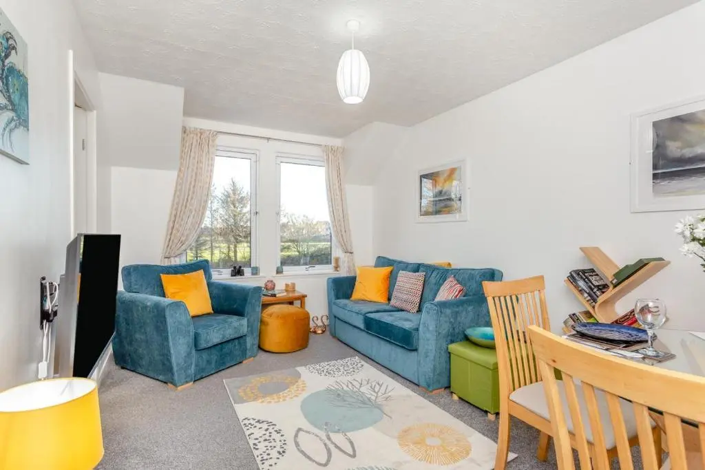 a living room with a blue couch and two chairs at 2 Bed in Nairn oc-t34496 in Nairn