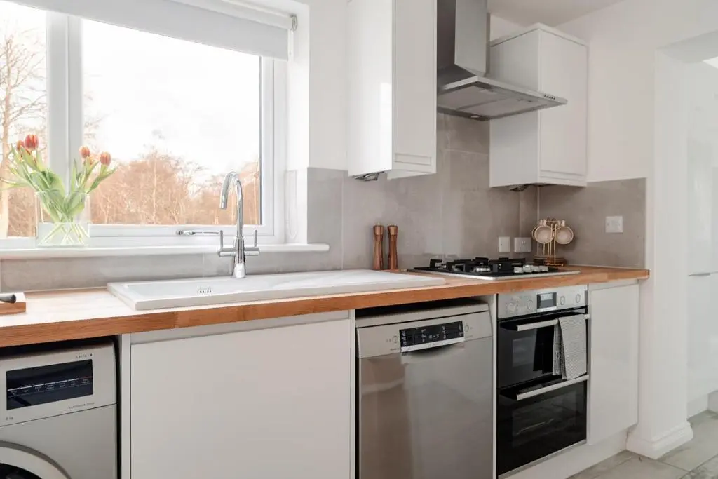 a kitchen with white cabinets and a sink and a window at Inshlea - Seasgair Lodges in Insh