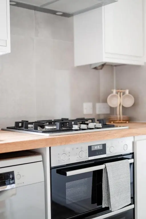 a kitchen with a stove and white cabinets at Inshlea - Seasgair Lodges in Insh