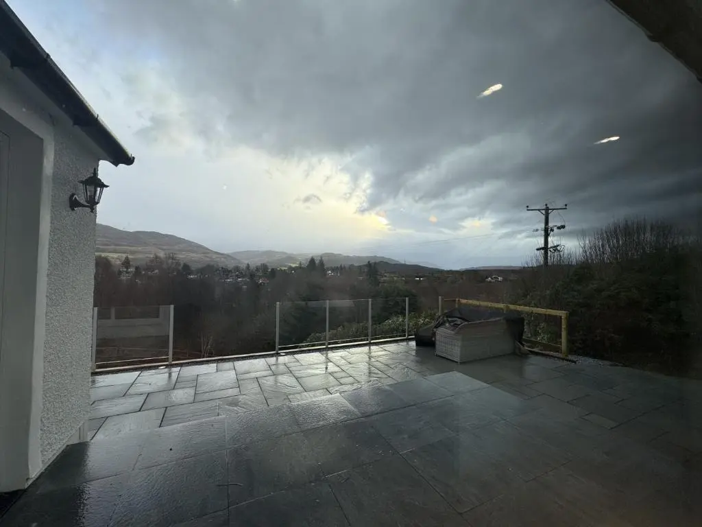 a balcony with a couch and a view of the mountains at Sunny Ridge in Fort Augustus