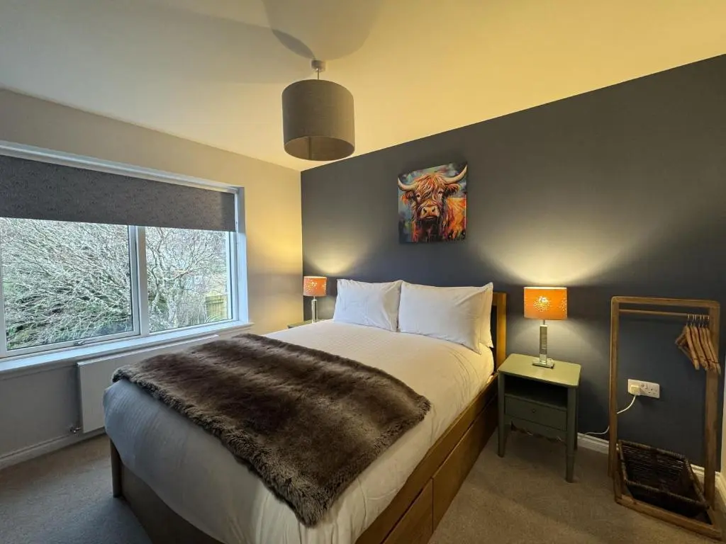 a bedroom with a large bed and a window at Sunny Ridge in Fort Augustus