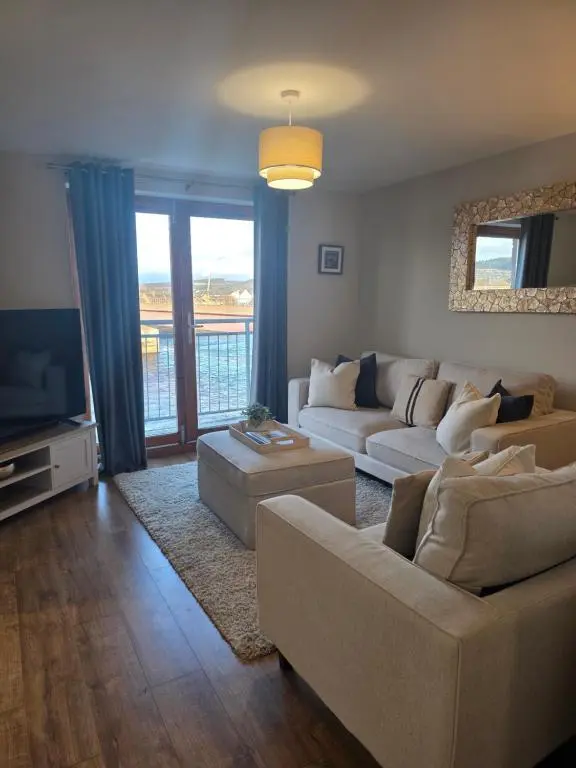 a living room with two couches and a television at Riverside View in Inverness